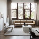 salon con soba y butaca alfombra cruda sobre pavimento de madera cortinas beige 5b5ce0fd 1200x630